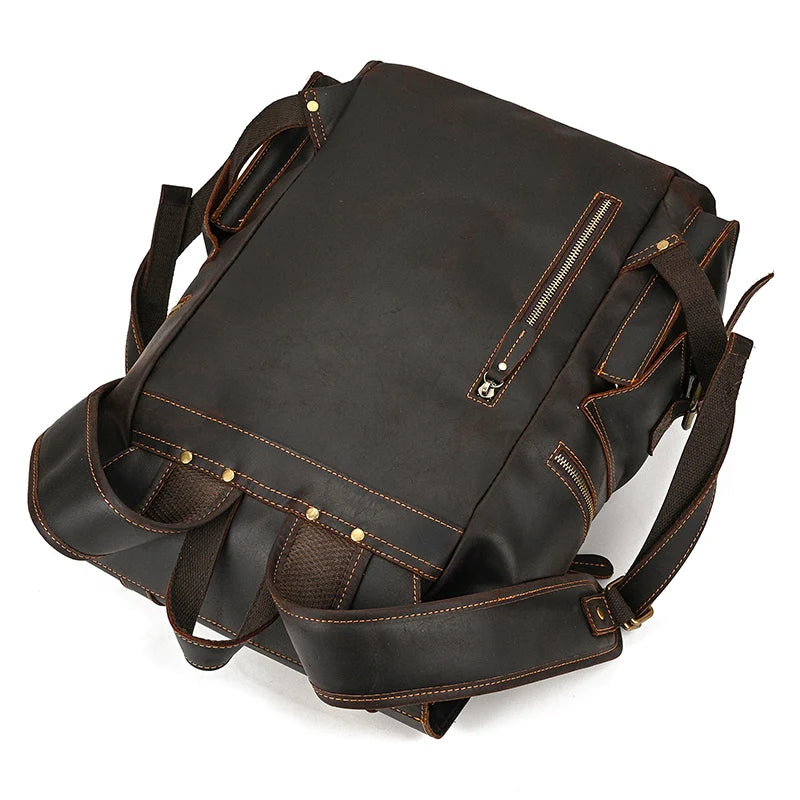 The Genuine Leather Travel Backpack is a dark brown, vintage-style accessory crafted from genuine leather. It boasts multiple compartments and features detailed brown stitching. The design includes a front zippered pocket, mesh pockets, and adjustable shoulder straps, providing a rugged and utilitarian look that is perfect for both travel and daily use.