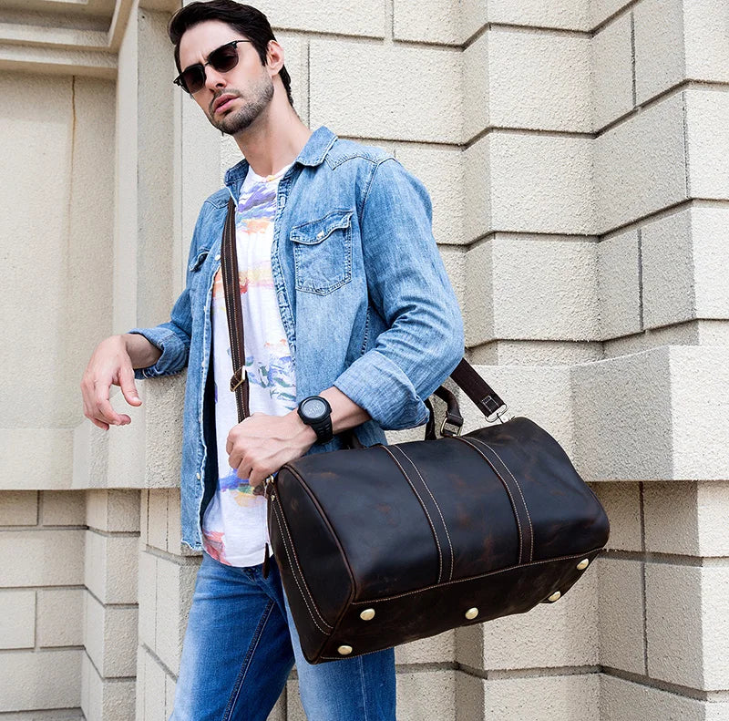 Man carrying Weekender 18 leather bag with spacious interior pockets for stylish and functional storage.