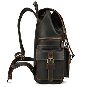 Side view of the Genuine Leather Travel Backpack, featuring a vintage style in black leather with brown stitching. The bag includes one large front pouch secured with a buckle closure, a smaller zippered pocket above it, and adjustable shoulder straps. Crafted from durable cow leather, the material appears to be high-quality.