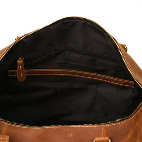 A view of the interior of the Weekender 24 Duffle Bag with a black fabric lining. Crafted from genuine cowhide leather, it features a zippered pocket along the back wall and several smaller open pockets in front. The top zipper is partially open, revealing spacious interior compartments that are perfect for travelers.