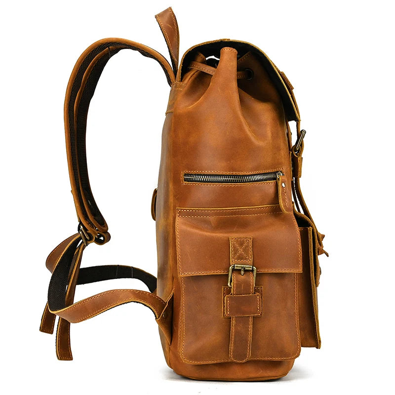 A side view of the Genuine Leather Travel Backpack showcases its vintage aesthetics in a beautiful brown color. The bag features multiple pockets and straps, including a drawstring closure on top, a zippered pocket on the front, and an additional buckled pocket. Made from durable cow leather, it also includes padded and adjustable shoulder straps for extra comfort.