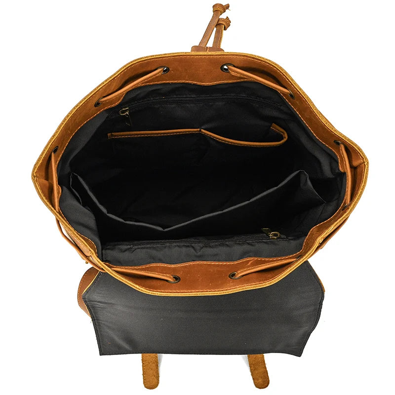 Open the Genuine Leather Travel Backpack to reveal its spacious interior. Featuring a main compartment with black lining, a zippered pocket, and additional open pockets, it’s designed for optimal organization. Crafted from durable cow leather, its vintage aesthetics enhance both style and function.