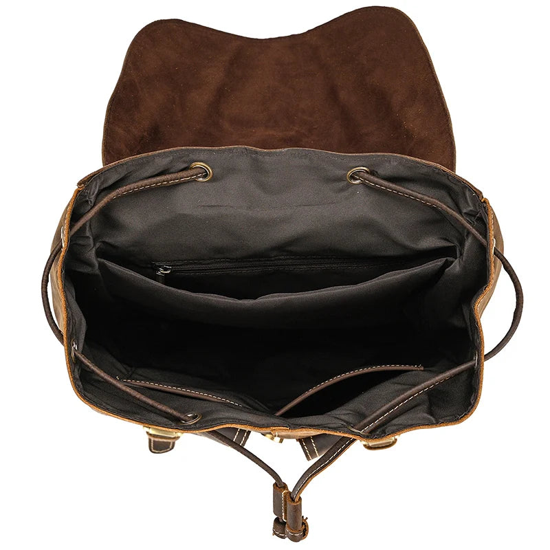 Open the Genuine Leather Vintage Backpack, which boasts a softback design with a brown leather exterior and a casual suede interior. From above, you'll see two spacious compartments and adjustable drawstrings, all crafted from genuine leather.