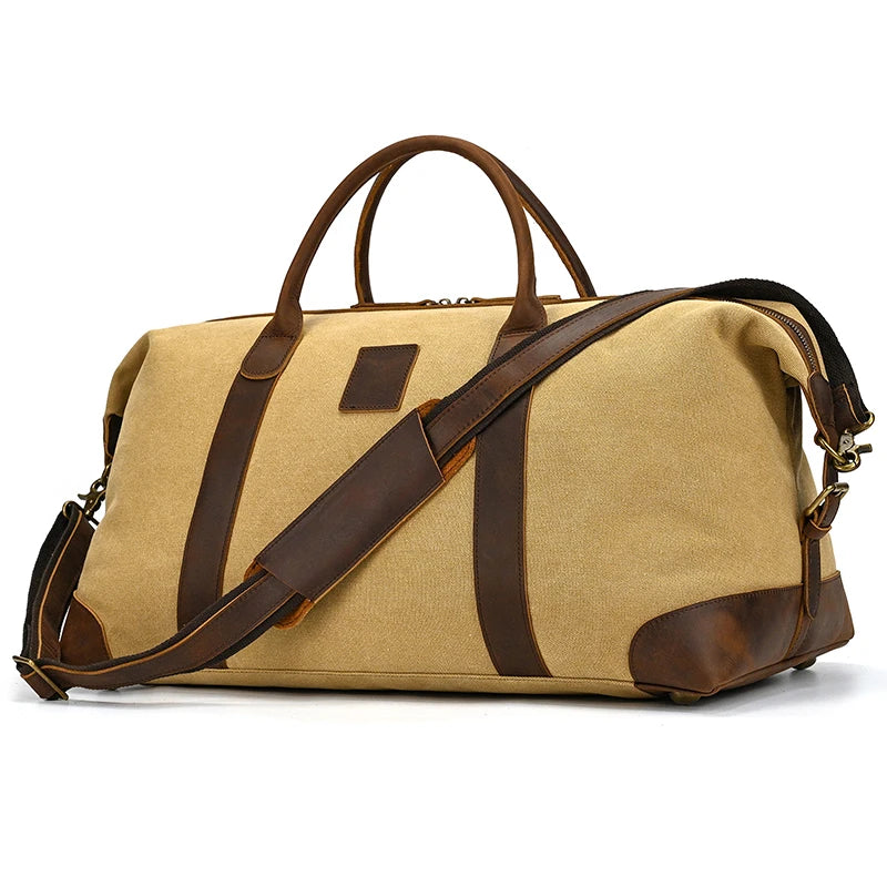 The Canvas & Leather Travel Duffle is a large beige bag exuding vintage charm with brown leather accents and handles, plus a detachable shoulder strap, showcased against a plain white background.