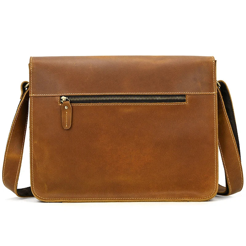 The Vintage Shoulder Bag is crafted from genuine brown cowhide leather and features a front zipper pocket along with an adjustable shoulder strap. It showcases a clean, minimalist design with visible stitching along the edges, making it perfect for business trips.