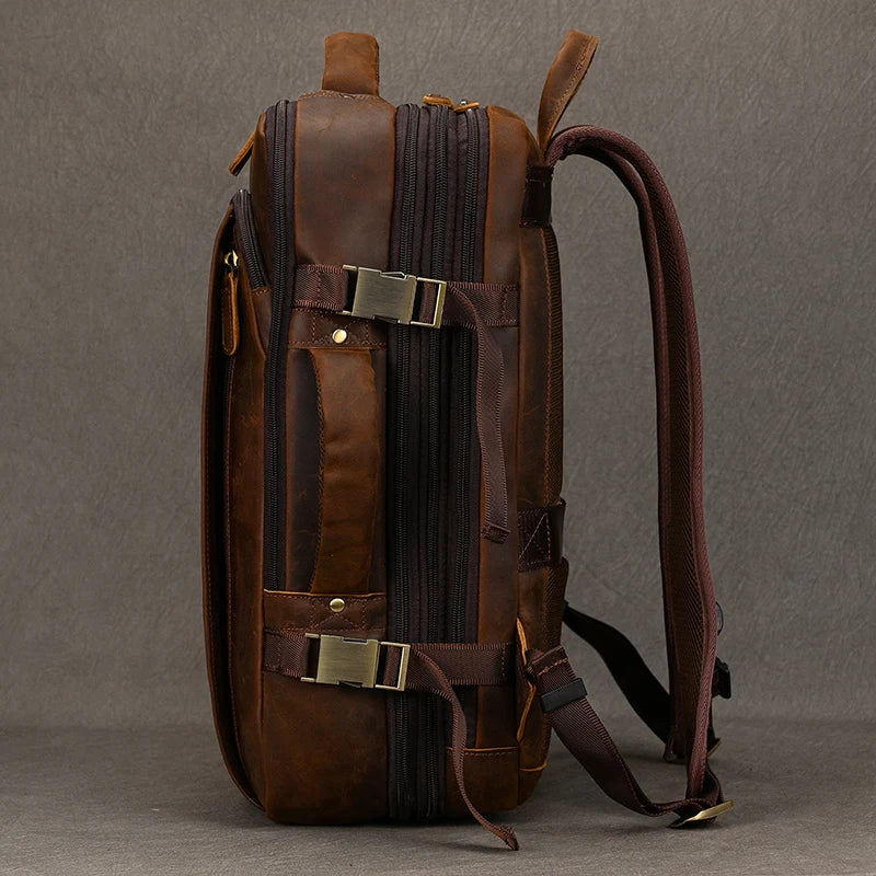 Side view of the Vintage Leather Travel Backpack made from brown leather, showcasing its authentic buckles and zippers. This handmade backpack features a sturdy handle and adjustable shoulder straps, elegantly presented against a plain gray background.