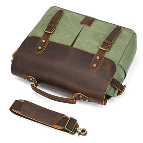 The Canvas & Leather Vintage Messenger Bag has a green fabric body, brown leather straps with brass buckles, and a detachable leather shoulder strap with metal clasps. Its stylish design is completed by a prominent genuine leather flap.