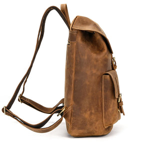 A side view of the Genuine Leather Vintage Backpack showcases its genuine leather craftsmanship, adjustable shoulder straps, and front pocket. The bag is designed with a flap closure and embodies a casual vintage style.