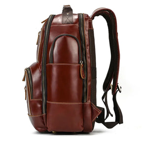 The side view of the **Vintage Leather Travel Backpack** highlights its craftsmanship from genuine cowhide leather. This sleek and polished backpack offers padded shoulder straps and an abundance of storage options with multiple zippered compartments and a mix of small and large pockets, making it perfect for carrying various items.