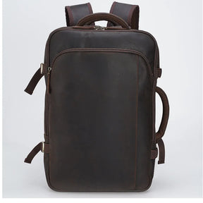 Introducing the Vintage Leather Travel Backpack: a dark brown genuine leather creation with multiple compartments, side handles, and padded shoulder straps. Its sleek, rectangular design exudes vintage style, making it perfect for travel or daily use as a men's softback accessory with timeless appeal.