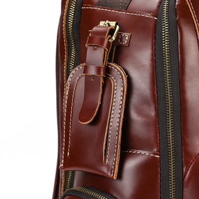 Close-up of the Vintage Leather Travel Backpack showcasing its buckle strap and intricate stitching details. The side view reveals a metal zipper paired with black fabric lining, enhancing its rugged and durable aesthetic. The lighting accentuates the rich texture of the genuine cowhide leather.