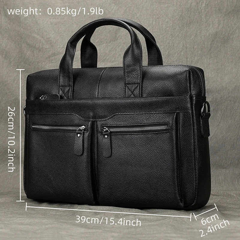 The 15" Black Briefcase, crafted from sleek genuine leather and displayed against a grey background, showcases its dimensions (26cm x 39cm x 6cm) and weight (0.85kg/1.9lb) in white text. This professional handbag features an adjustable strap, two front zippered pockets, and sturdy handles.