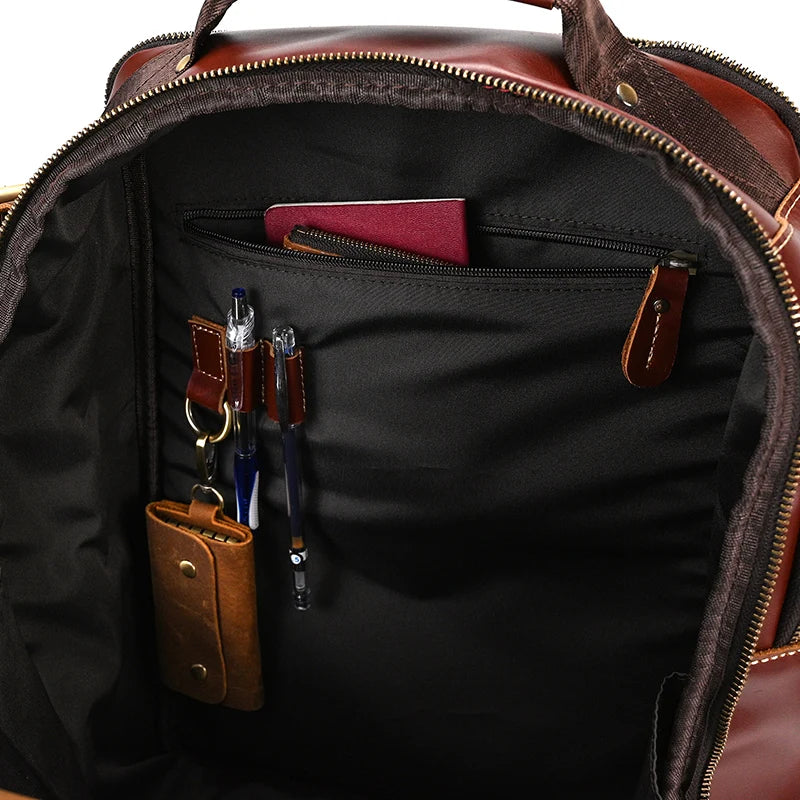 The Vintage Leather Travel Backpack displays its well-organized interior with ample storage, crafted from genuine cowhide leather and featuring several pockets. Inside, you'll find two pens, keys securely held on a key holder, a brown wallet, and a maroon passport conveniently tucked into a zippered pocket. The interior is lined with black fabric.