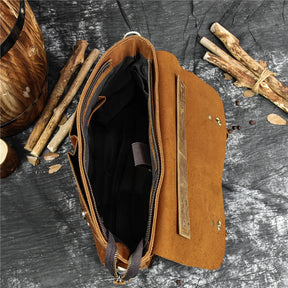 A scene featuring the Leather 14" Briefcase Shoulder Bag: a brown leather briefcase with its top flap open to reveal a sleek black interior. The genuine cowhide bag is set on a textured grey surface and surrounded by wooden sticks, creating a rustic and natural aesthetic.