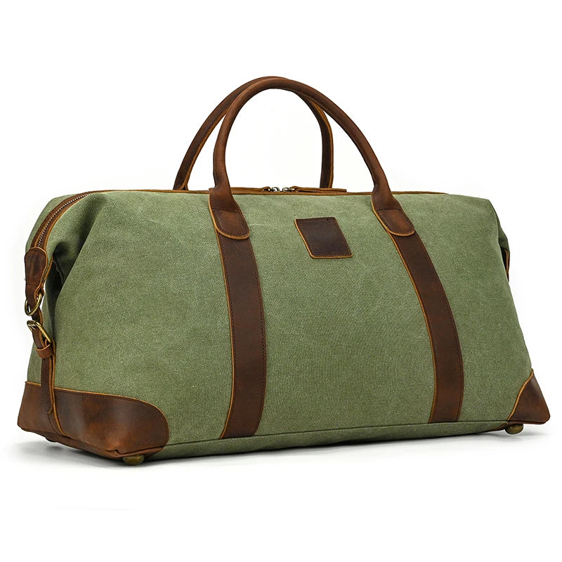 The Canvas & Leather Travel Duffle is a large green bag with genuine leather handles and trim, a top zipper, and an adjustable shoulder strap. This vintage-inspired design includes protective leather corners, a sturdy base, and ample space.