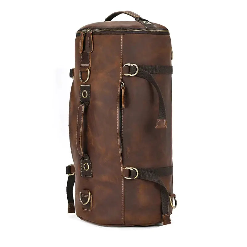 Introducing the Vintage Leather Travel Backpack: a tall, authentic cowhide leather bag with a cylindrical design, featuring multiple buckles, handles, and straps. Ideal for the fashionable traveler, it comes equipped with a top zipper and numerous metal rings for attachments, offering remarkable versatility.