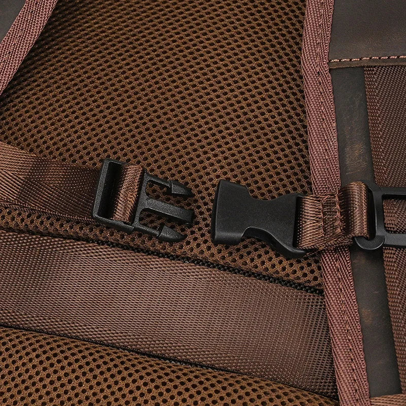 Close-up of the Vintage Leather Travel Backpack showcasing brown mesh with adjustable straps and a black plastic buckle. The genuine leather-trimmed straps are securely fastened by the clipped buckle.