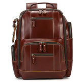 The Vintage Leather Travel Backpack is a stylish accessory made of genuine cowhide leather, featuring multiple zippered compartments. It includes a padded handle on top, adjustable shoulder straps, and side pockets. The compartments are highlighted by white stitching, enhancing its elegant design and providing ample storage space.