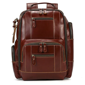 The Vintage Leather Travel Backpack is a stylish accessory made of genuine cowhide leather, featuring multiple zippered compartments. It includes a padded handle on top, adjustable shoulder straps, and side pockets. The compartments are highlighted by white stitching, enhancing its elegant design and providing ample storage space.