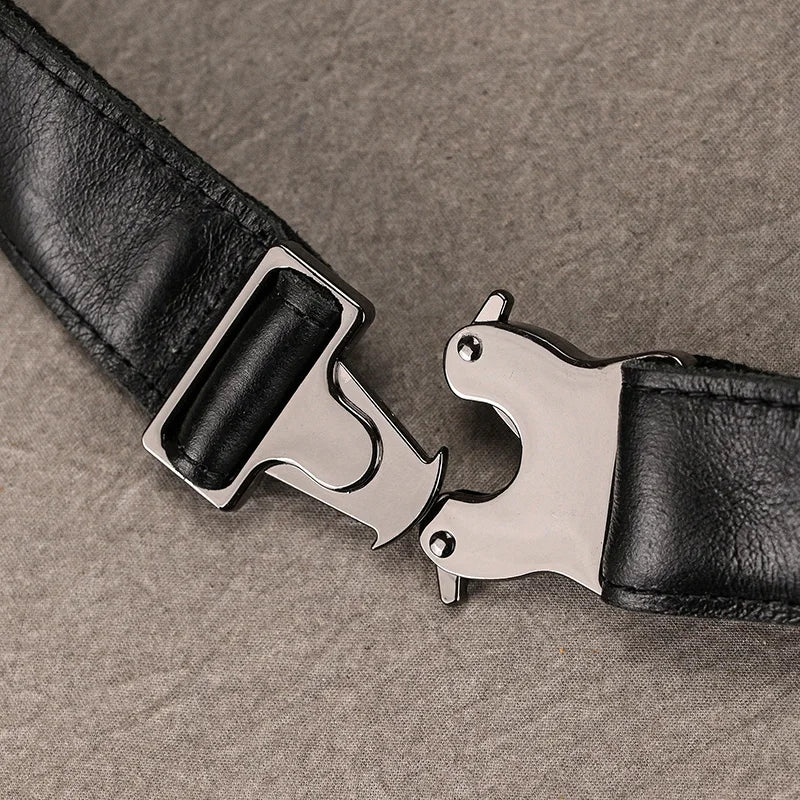 A close-up of the Leather Belt Bag in black leather, featuring a metallic clasp buckle, lying on a gray textured surface. The partially open buckle reveals its intricate locking mechanism made from durable alloy hardware.