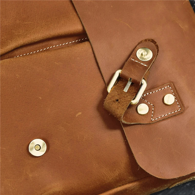 Here is a close-up of the Leather 14" Briefcase Shoulder Bag crafted from genuine cowhide with a slightly worn texture. The briefcase features a silver-colored buckle and clasp, and visible stitching that enhances its rugged and professional style.