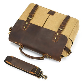 The Canvas & Leather Vintage Messenger Bag in tan and dark brown exudes a refined business style with brass buckles, two handles, and a detachable shoulder strap with leather padding, resting on a white background to embody elegance and functionality.