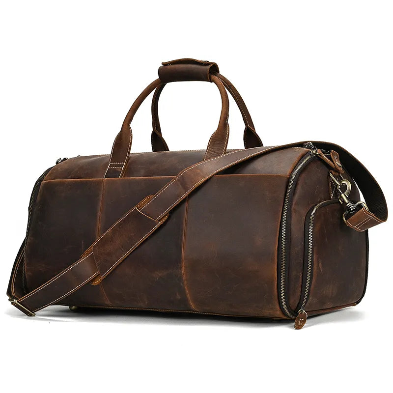 Introducing the Luggage 22 Leather Travel Duffle Bag: A rugged brown duffle bag made from genuine leather, featuring two sturdy handles and an adjustable, removable shoulder strap. This bag is equipped with metal zippers and flaunts a vintage, distressed finish. Its chamfered corners and structural design ensure durability and ample storage space.