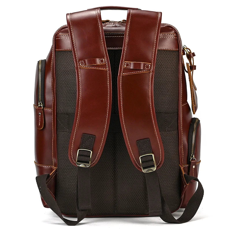 The Vintage Leather Travel Backpack boasts padded adjustable straps and metal buckles. The black, mesh-textured back panel ensures ventilation. Ample storage is provided by multiple zippers and pockets on the sides and rear, while the top features a genuine cowhide leather handle for easy carrying.