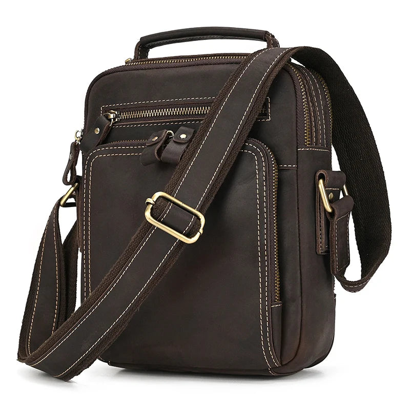 The Dark Brown Leather Shoulder Bag boasts multiple compartments and zippers, a sturdy top handle, and an adjustable shoulder strap with alloy hardware. Crafted from genuine cowhide leather, it showcases visible stitching and a sleek, functional design.