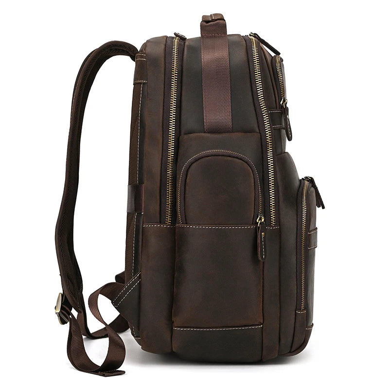 Side view of the Genuine Leather Backpack with USB Charging, crafted from dark brown leather. This unisex design features multiple zippered compartments, adjustable shoulder straps, and a sturdy handle on top while boasting a sleek and polished finish.