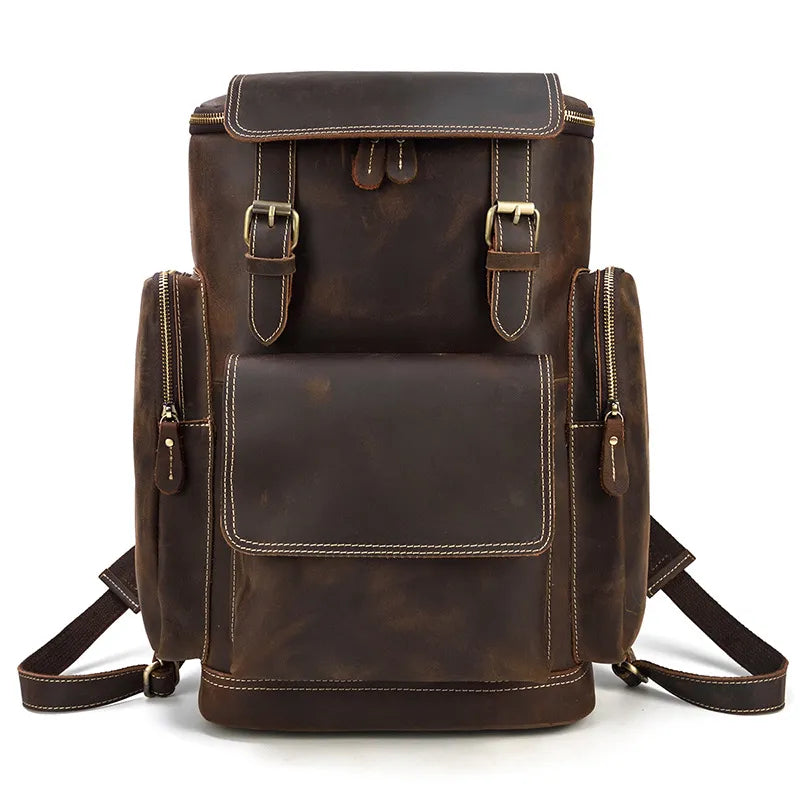 The Vintage Leather Travel Backpack is a spacious vintage-style accessory crafted from genuine cowhide leather. It features two small side pockets and a front pocket equipped with a flap closure and buckled straps. The top boasts twin buckle closures, adjustable shoulder straps for comfort, and an overall rustic appearance. Additionally, it includes a convenient laptop compartment.