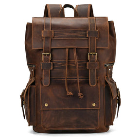 The Genuine Leather Travel Backpack in Light Brown is a durable piece of travel gear with a rustic, vintage design. It features two adjustable shoulder straps, two side pockets with buckle closures, a front pocket with leather string tie closure, and metal buckles securing the front flap.