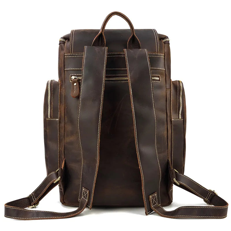 Take a look at the back view of the Vintage Leather Travel Backpack. This large, genuine cowhide leather bag showcases two adjustable padded shoulder straps for comfortable carrying. It includes multiple zippered compartments, a laptop compartment, reinforced stitching, and a top handle for easy transport. The slightly worn appearance gives it a distinctive vintage charm.