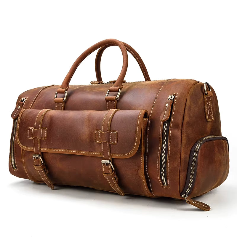 The Weekender 20 Leather Travel Bag, made of genuine cowhide, has multiple pockets and zippers, sturdy handles, and visible stitching. This large brown duffel also includes a shoe compartment and buckled side and front pockets for extra security.