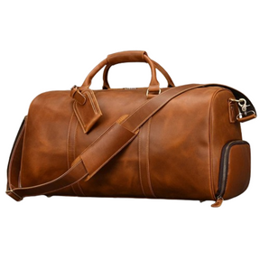 The Weekender Duffle 22 Leather Travel Bag is a brown leather duffel featuring sturdy handles, an adjustable shoulder strap, and an attached luggage tag. Made from smooth, high-quality genuine cowhide leather, the bag also has side zippers for added convenience.