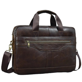 The 16" Brown Leather Briefcase is a dark brown, genuine leather handbag that features a large zippered pocket on the front, handles, and a detachable adjustable strap with metal clasps. It boasts a polished leather finish with visible stitching and is set against a plain white background.