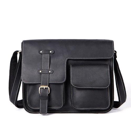 The Vintage Shoulder Bag is a stylish black leather accessory, boasting white stitching and a sleek design. It features a flap closure with a distinctive buckle accent and two front pockets in different sizes. Crafted from genuine cowhide leather, the bag comes with an adjustable shoulder strap, merging functionality with elegance—ideal for business trips.